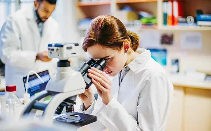 doctor looking through microscope
