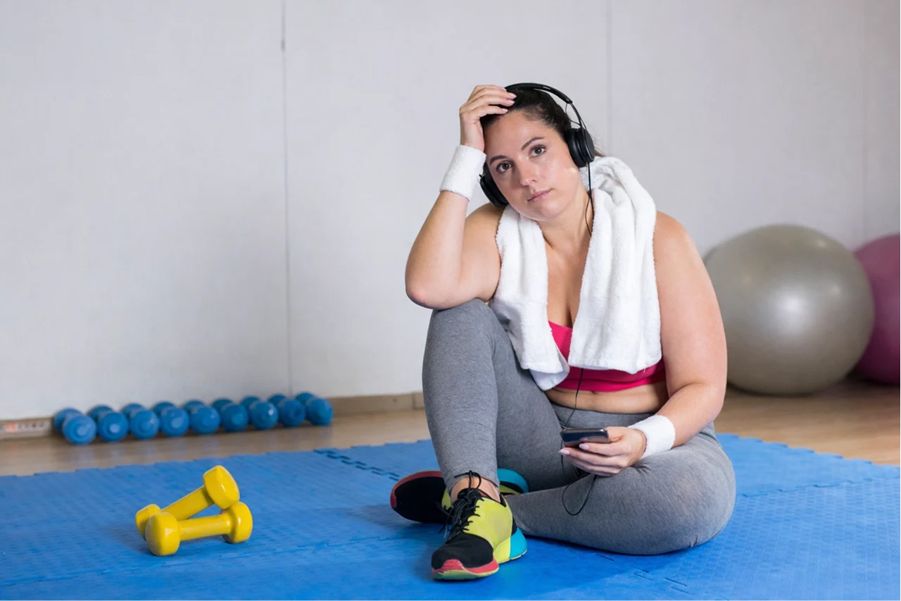depressed overweight woman in a gym